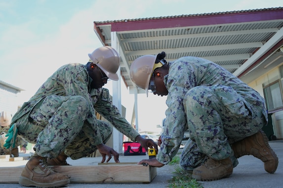 Builder 2nd Class Tivonja Johnson, right, and Builder Constructionman Keandre Gilbert, both assigned to Naval Mobile Construction Battalion 4, create lumber cut measurements during facility renovations at Vaiola Hospital as part of PP-25 in Nuku’Alofa, Tonga, June 21, 2025.