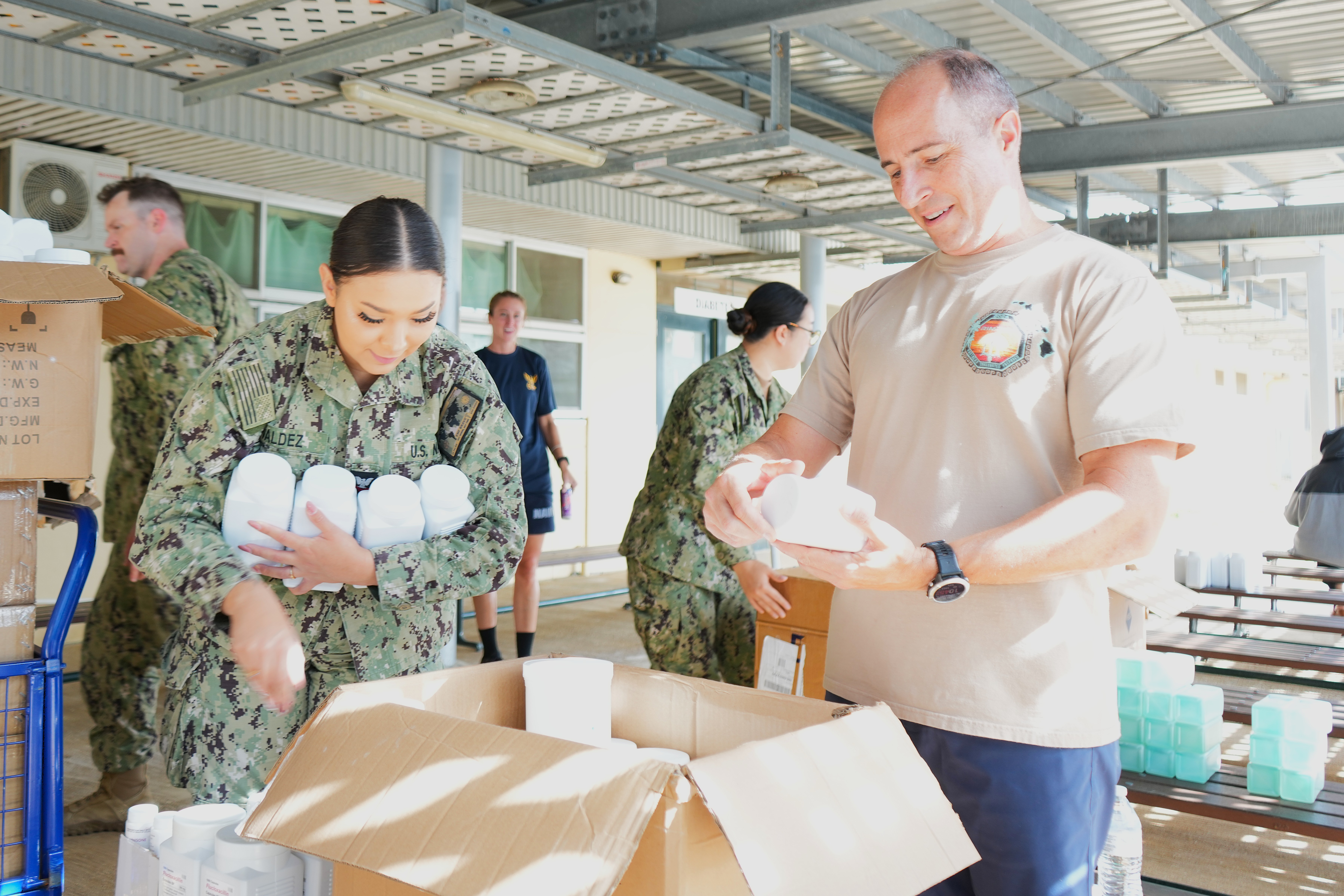 U.S. Navy Capt. Mark B. Stefanik, right, mission commander of Pacific Partnership 2025 (PP-25), and Hospital Corpsman 2nd Class Sheccid Valdez, assigned to Expeditionary Medical Facility (EMF) 150-Bravo, organize boxes of medical supplies at Vaiola Hospital as part of PP-25 in Nuku’Alofa, Tonga, June 21, 2025.