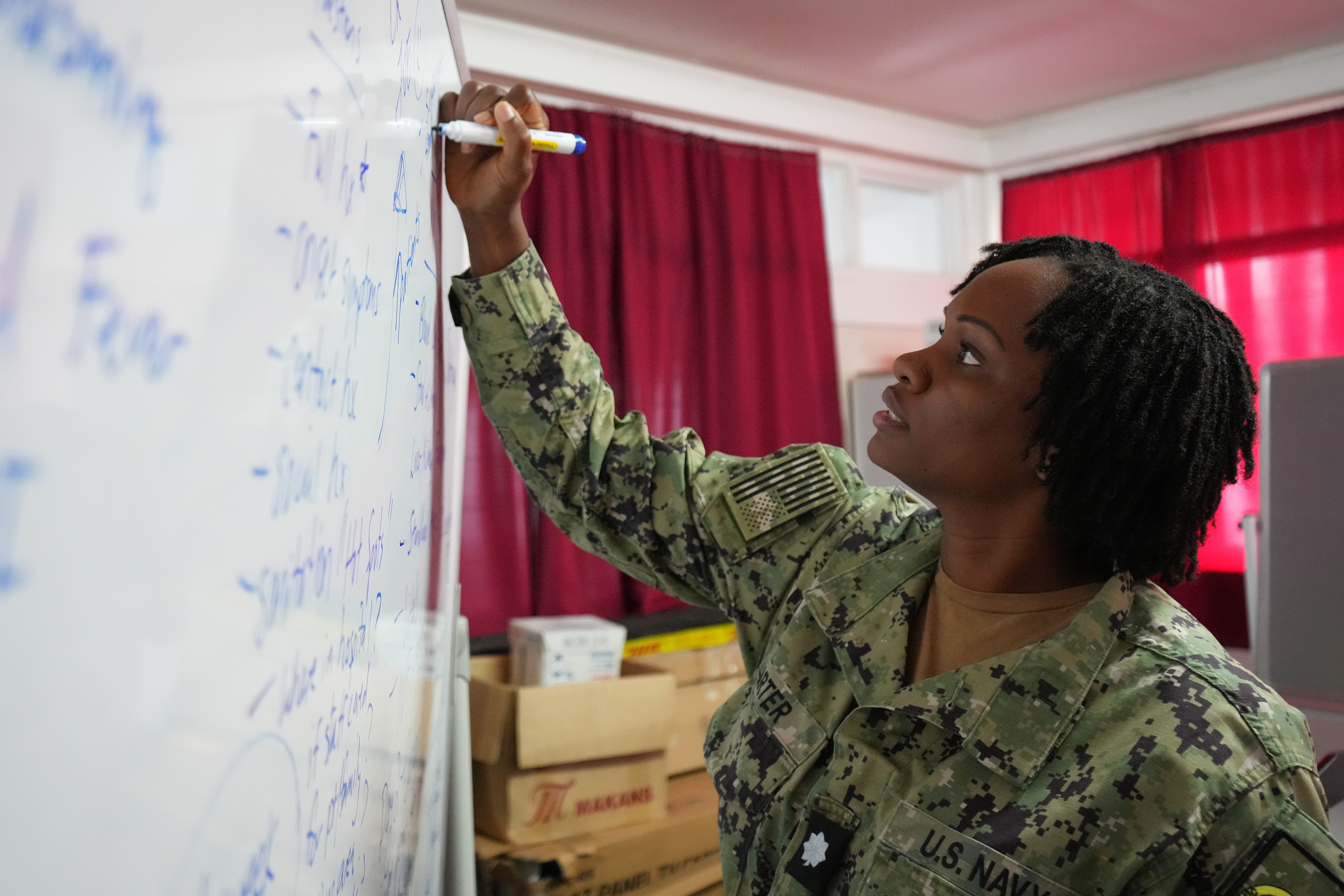 U.S. Navy Cmdr. Christina Carter, public health nurse deployed in support of Pacific Partnership 2025 (PP-25), writes on a whiteboard during a tabletop training exercise with local nurses of Vaiola Hospital as part of PP-25 in Nuku’Alofa, Tonga, June 26, 2025.