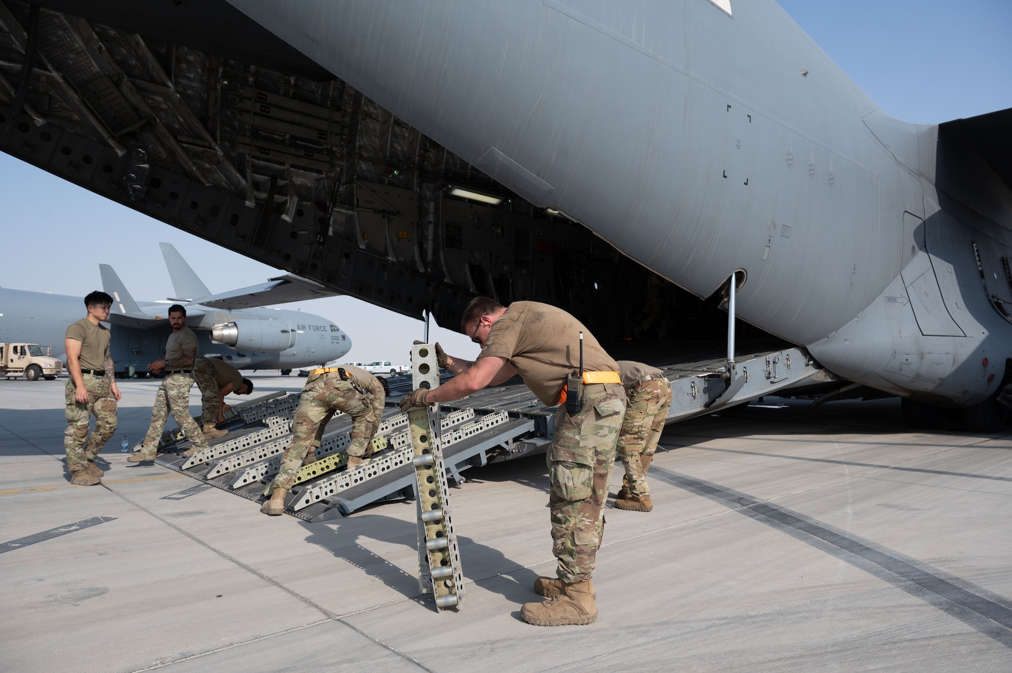 U.S. Air Force Airmen assigned to the 379th Expeditionary Air Base Group place rollers on a C-17 Globemaster III during a rapid aircraft departure within the U.S. Central Command area of responsibility, June 15, 2025.The 379th EABG accelerates readiness and embraces change to serve as a symbol for the future of Air Force deployed operations. (U.S. Air Force photo by Senior Airman Dieondiere Jefferies)