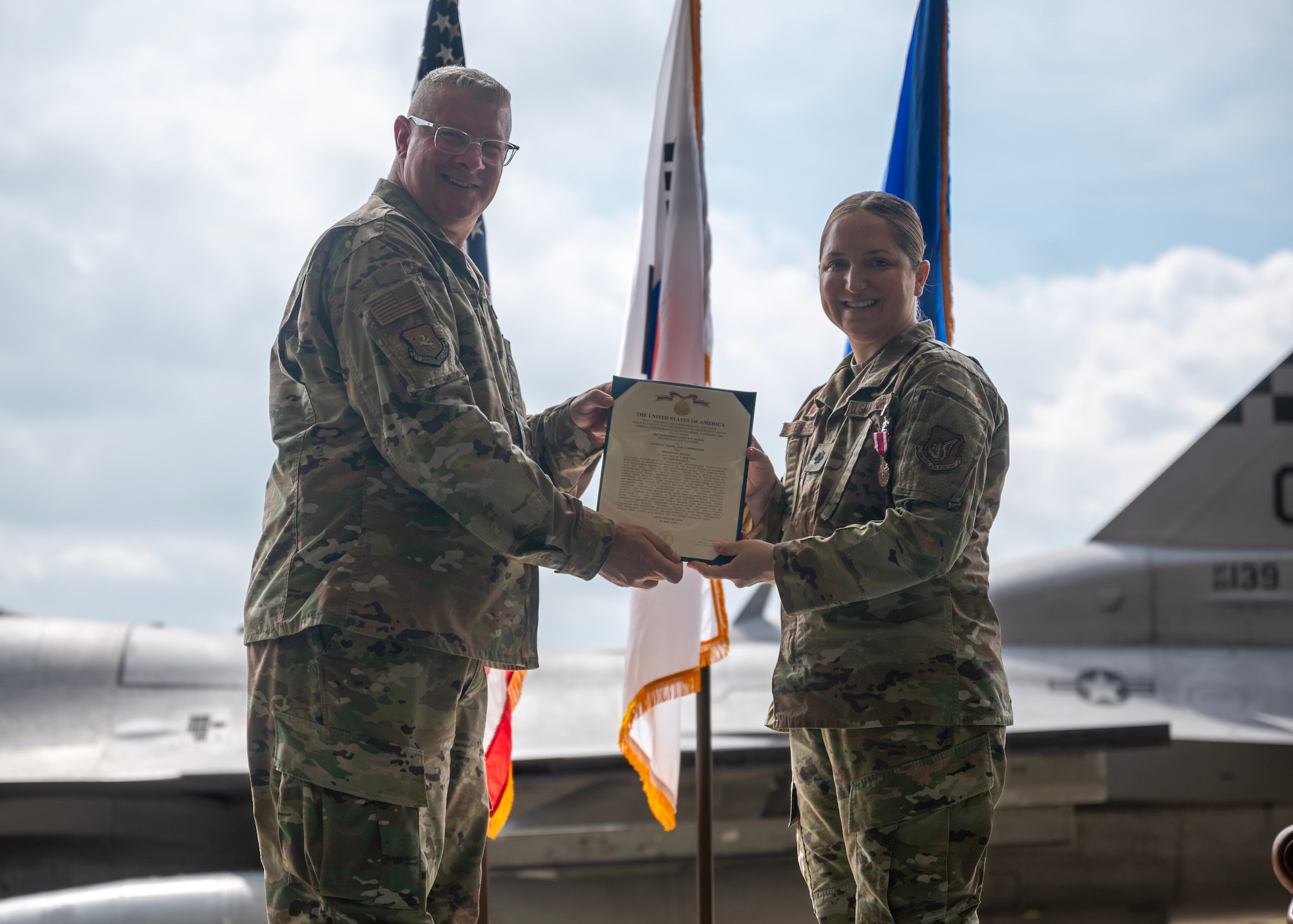 U.S. Air Force Lt. Col. Evin Greensfelder, right, outgoing 51st Maintenance Squadron commander, receives the Meritorious Service Medal from Col. Kenneth Beebe, 51st Maintenance Group commander, during a Change of Command ceremony at Osan Air Base, Republic of Korea, July 2, 2025. Greensfelder ensured the safe, quality execution of on-and-off equipment maintenance for 60 A-10 Thunderbolt II, F-16 Fighting Falcon, and U-2 Dragon Lady aircraft and 82 aircraft engines supporting over 8,000 annual combat training sorties. (U.S. Air Force photo by Staff Sgt. Sarah Williams)