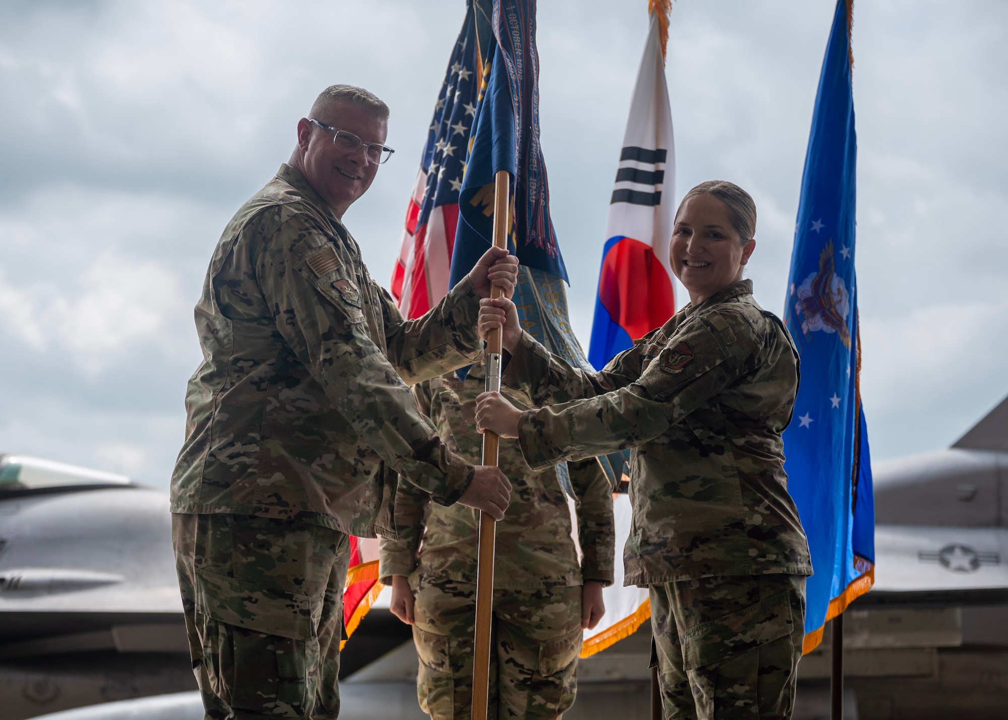 U.S. Air Force Lt. Col. Evin Greensfelder, right, outgoing 51st Maintenance Squadron commander, relinquishes command to Col. Kenneth Beebe, 51st Maintenance Group commander, during a Change of Command ceremony at Osan Air Base, Republic of Korea, July 2, 2025. Greensfelder served as a three-time squadron commander and held various leadership positions as a field-level Aircraft Maintenance officer across four Major Commands. (U.S. Air Force photo by Staff Sgt. Sarah Williams)