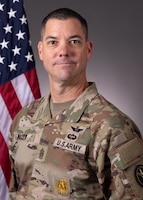 Portrait photo with US flag in the background of U.S. Army Command Sergeant Major Kevin J. Miller wearing Army combat uniform.