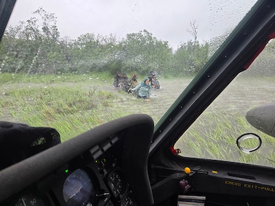 Alaska Army National Guard Chief Warrant Officer 3 Nick Lime, an aviator assigned to 207th Aviation Battalion, assists six distressed people stranded on the Kuskokwim River during a rescue mission June 30, 2025.