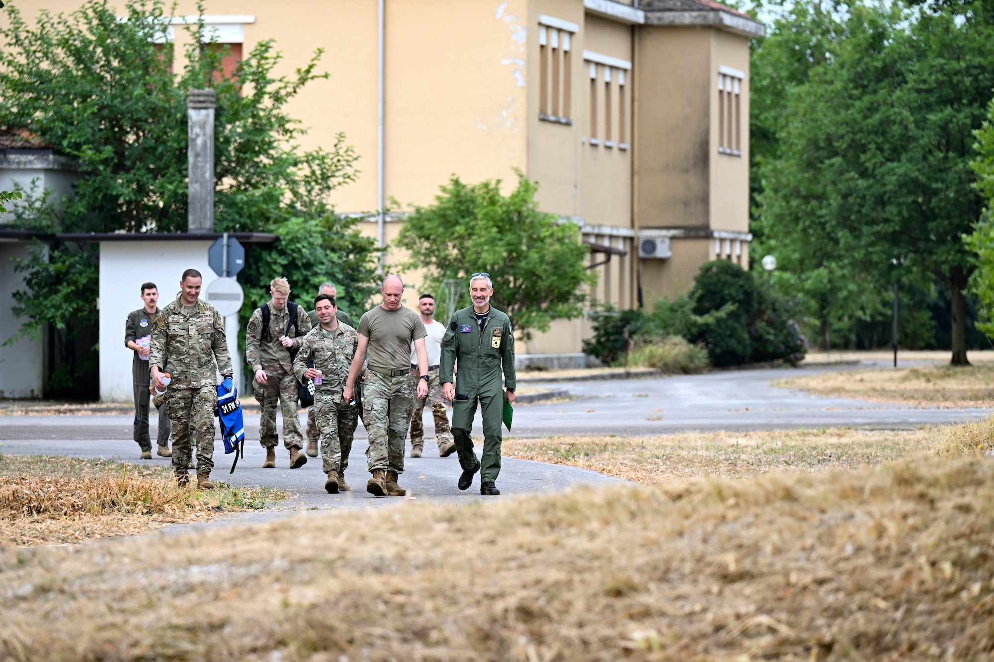 U.S. and Italian air force personnel walk together to begin an exercise.