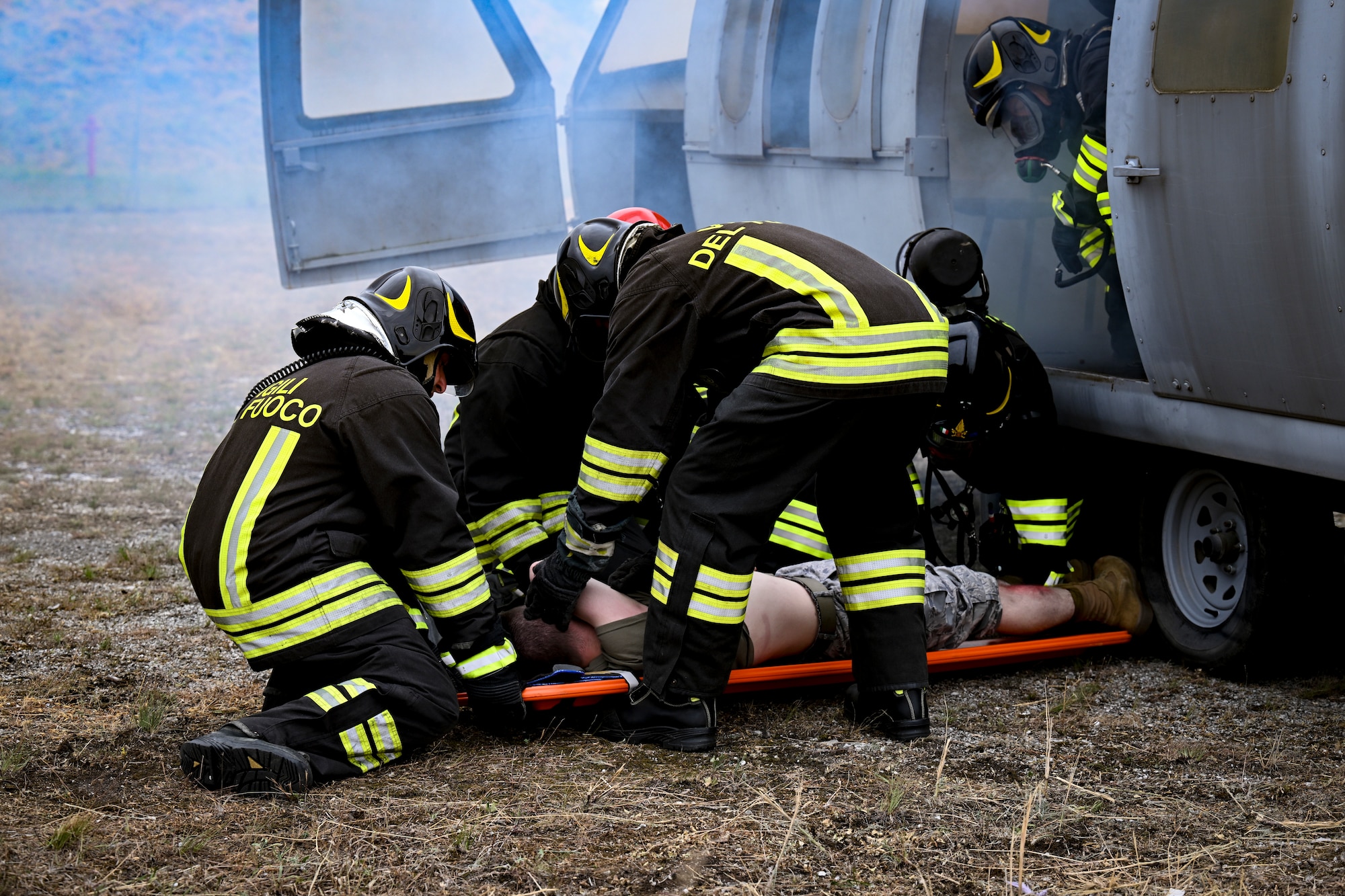 Italian firefighters lay simulated victim on a stretcher.