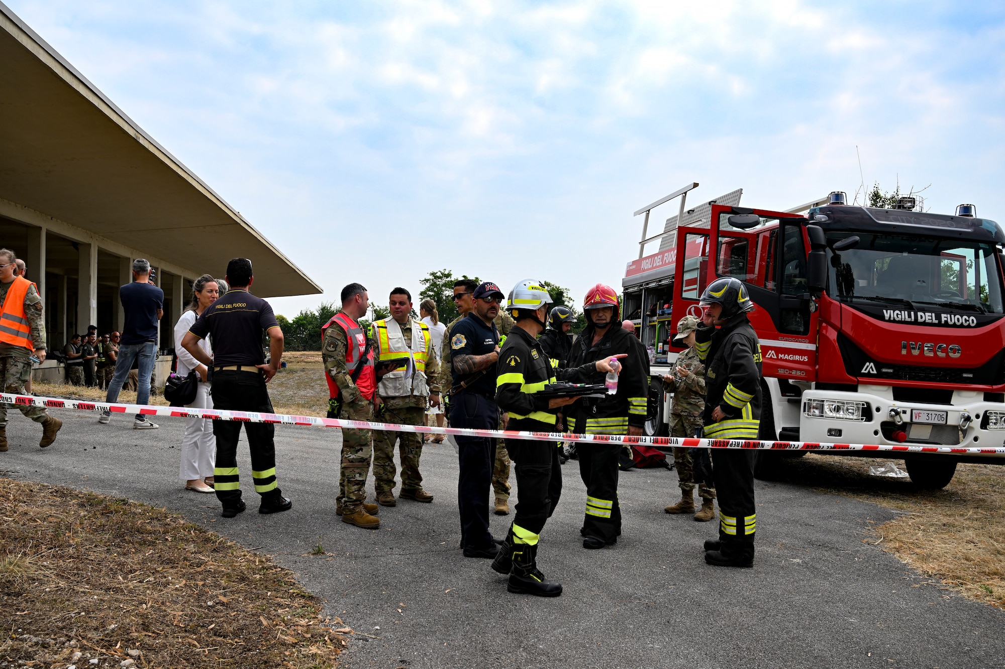 The 31st Fighter Wing, Italian air force and local Italian first responders stand around discussing an exercise.