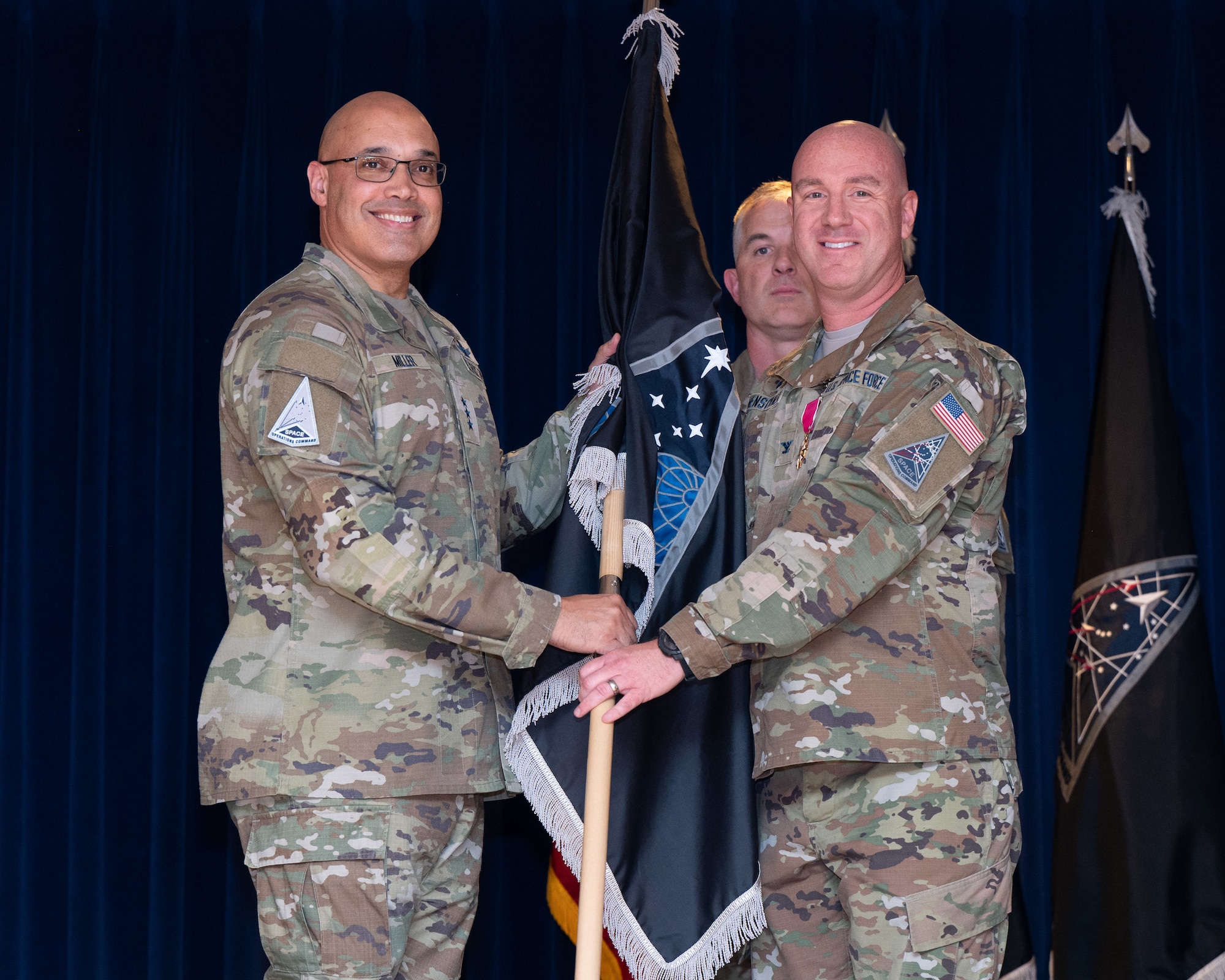 U.S. Space Force Lt. Gen. David N. Miller, Jr. (left) accepts the Mission Delta 31 (MD 31) flag from U.S. Space Force Col. Col. Andrew Menschner at a Change of Command Ceremony at Peterson Space Force Base, Colo., June 27, 2025. Menshner, MD 31's first commander, handed the reigns over to Col. Stephen Hobbs. MD 31 leads the United States Space Force's Positioning Navigation and Timing (Global Positioning System) and Satellite Control Network missions. (U.S. Space Force photo by Dave Grim)