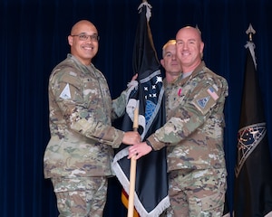 U.S. Space Force Lt. Gen. David N. Miller, Jr. (left) accepts the Mission Delta 31 (MD 31) flag from U.S. Space Force Col. Col. Andrew Menschner at a Change of Command Ceremony at Peterson Space Force Base, Colo., June 27, 2025.