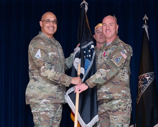  U.S. Space Force Lt. Gen. David N. Miller, Jr. (left) accepts the Mission Delta 31 (MD 31) flag from U.S. Space Force Col. Col. Andrew Menschner at a Change of Command Ceremony at Peterson Space Force Base, Colo., June 27, 2025.