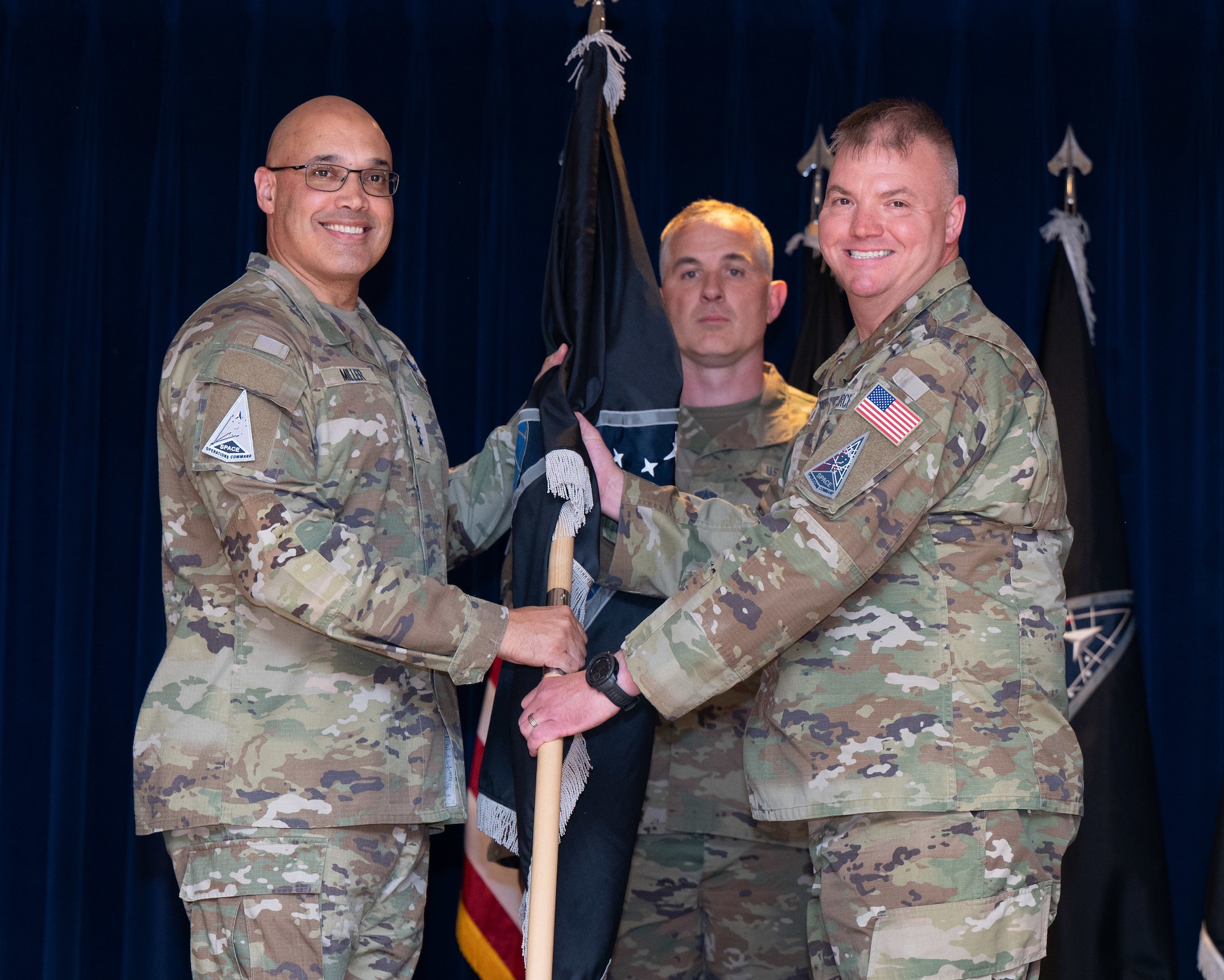 U.S. Space Force Lt. Gen. David N. Miller, Jr. presents the Mission Delta 31 (MD 31) flag to U.S. Space Force Col. Stephen Hobbs at a Change of Command Ceremony at Peterson Space Force Base, Colo., June 27, 2025. MD 31's first commander, Col. Andrew Menschner, handed the reins over to Hobbs. MD 31 leads the United States Space Force's Positioning Navigation and Timing (Global Positioning System) and Satellite Control Network missions. (U.S. Space Force photo by Dave Grim)