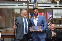 Steven Van Dyk, SSP's Chief Engineer, is presented with a trident and a plaque from Neil Choudhary, an engineer at SSP. Van Dyk has played a significant role in hiring and mentoring many young engineers, who now hold mid-level roles at SSP.