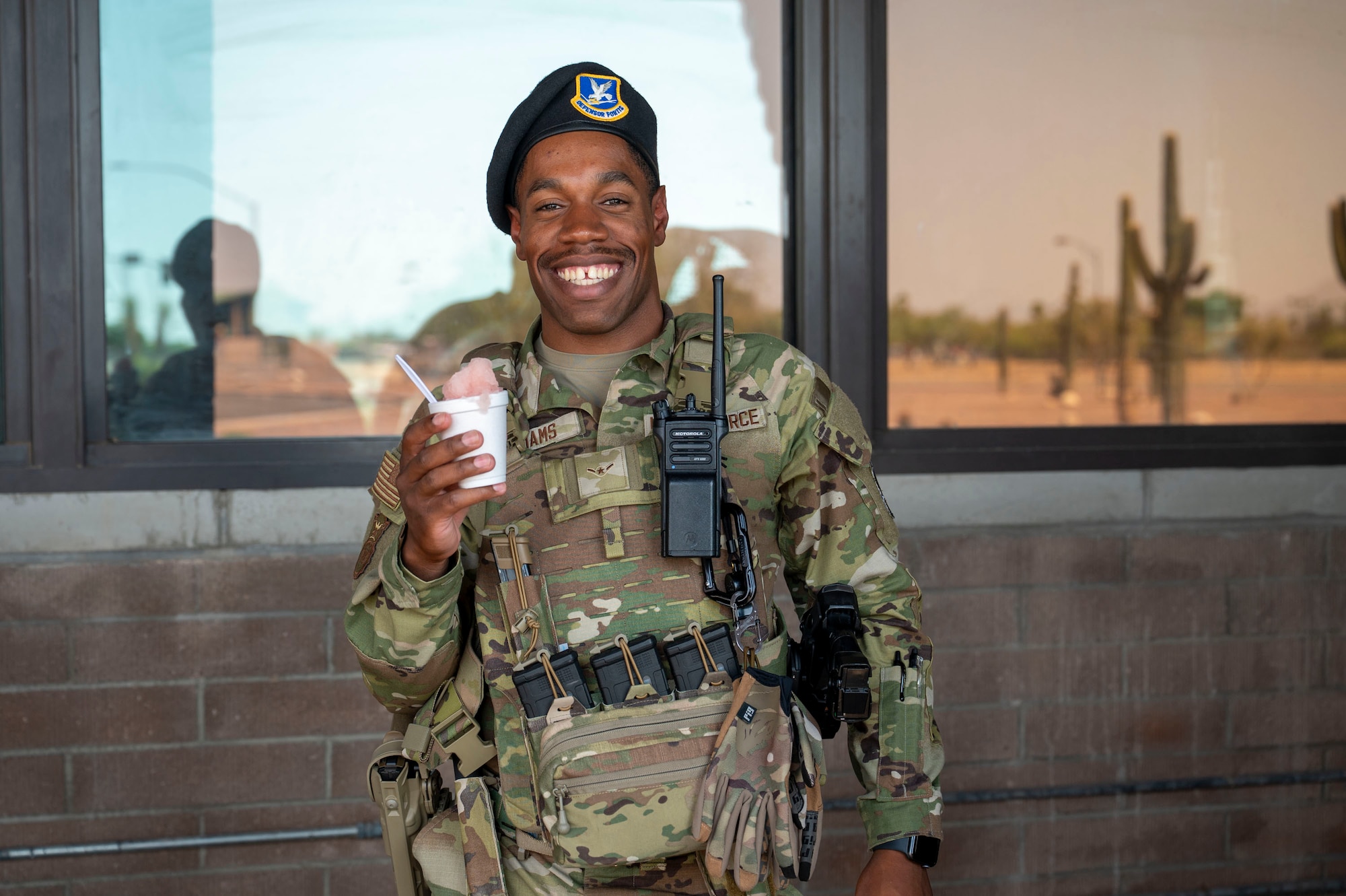 U.S. Air Force Airman Quincy Williams, 355th Security Forces Squadron response team member, poses for a photo with shaved ice provided by the Military Affairs Committee and the First Sergeants Council at Davis-Monthan Air Force Base, Arizona, July 1, 2025. The effort supported the well-being of Airmen working in high temperatures, reinforcing a culture of care and connectedness. (U.S. Air Force photo by Airman Samantha Melecio)