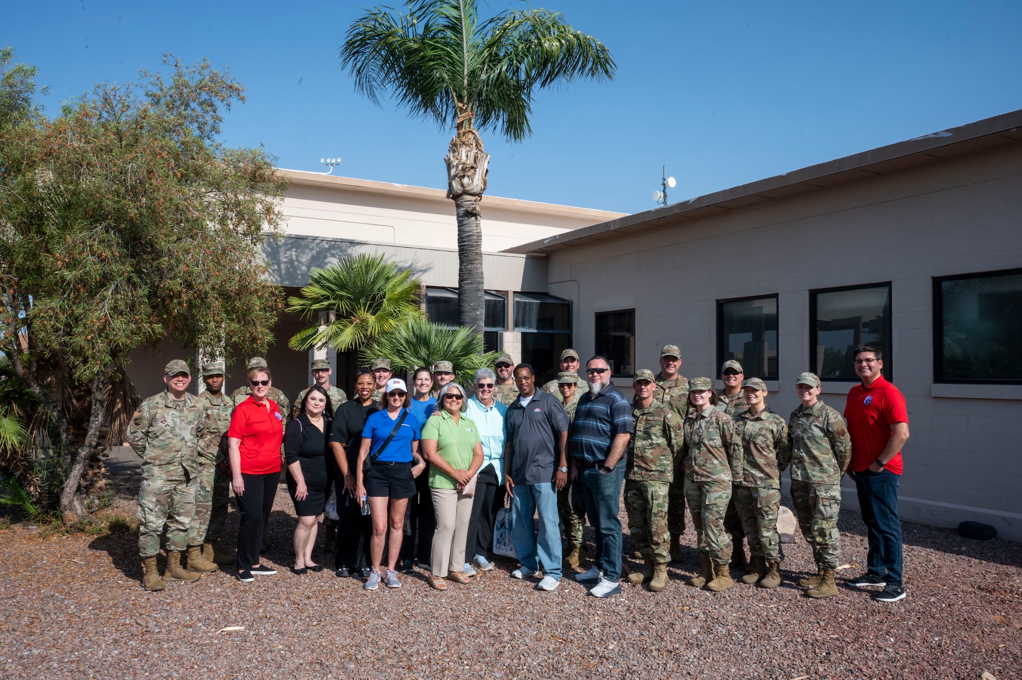 U.S. Air Force Airmen and Military Affairs Committee members pose for a group photo in front of the community center at Davis-Monthan Air Force Base, Arizona, July 1, 2025. The MAC partnered with the First Sergeants Council to visit various squadrons and hand out shaved ice, offering a refreshing break from the heat while fostering connection and morale among Airmen. (U.S. Air Force photo by Airman Samantha Melecio)
