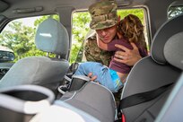 U.S. Air Force Staff Sgt. Brandon Schneider fastens his daughter Phoebe Schneider into a 3-point harnessed seat belt which is recommended by the National Highway Traffic Sector which is a sector of the Department of Safety.