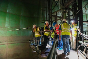 Steven Chow, far right, deputy facilities director, Navy Closure Task Force-Red Hill (NCTF-RH) speaks with visitors from the National Academies of Sciences, Engineering, and Medicine as they view fuel tank 19 during a site visit to the Red Hill Bulk Fuel Storage Facility (RHBFSF) in Honolulu, June 24, 2025. Charged with the safe decommissioning of the facility, NCTF-RH was established by the Department of the Navy as a commitment to the community and the environment. NCTF-RH continues to engage with the people of Hawaii, regulatory agencies, and other stakeholders as it safely and deliberately decommissions the RHBFSF. (U.S. Navy photo by Mass Communication Specialist 3rd Class Krystal Diaz)