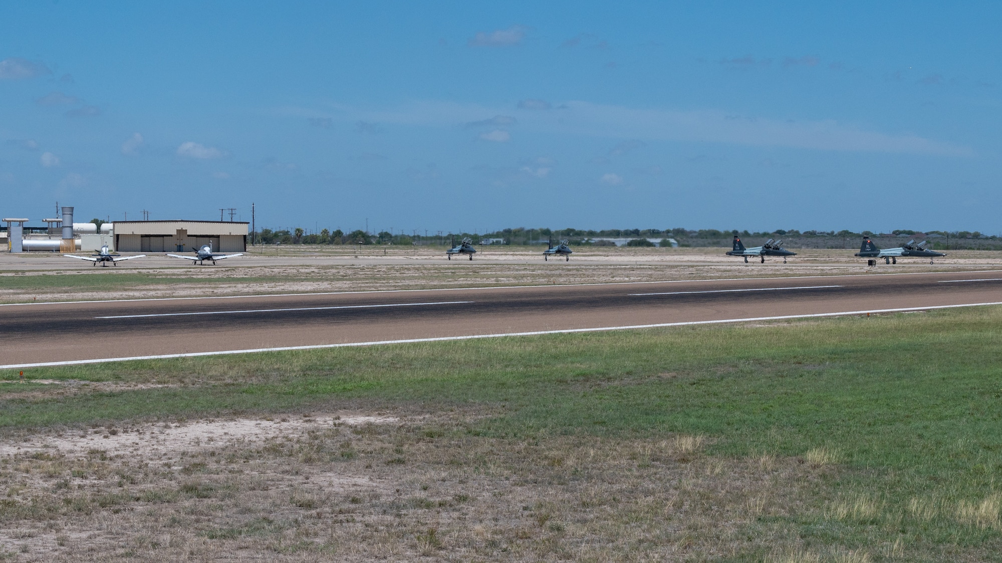 U.S. Air Force T-6A Texan II and T-38C Talon aircraft prepare to take off during an Uncontrolled Airfield Operations exercise at Laughlin Air Force Base, Texas, June, 26, 2025. The exercise simulated the tower being offline and unable to direct aircraft, forcing aircraft to rely on the Runway Supervisory Units to help ensure safety and operations. (U.S. Air Force photo by Staff Sgt. Nicholas Larsen)