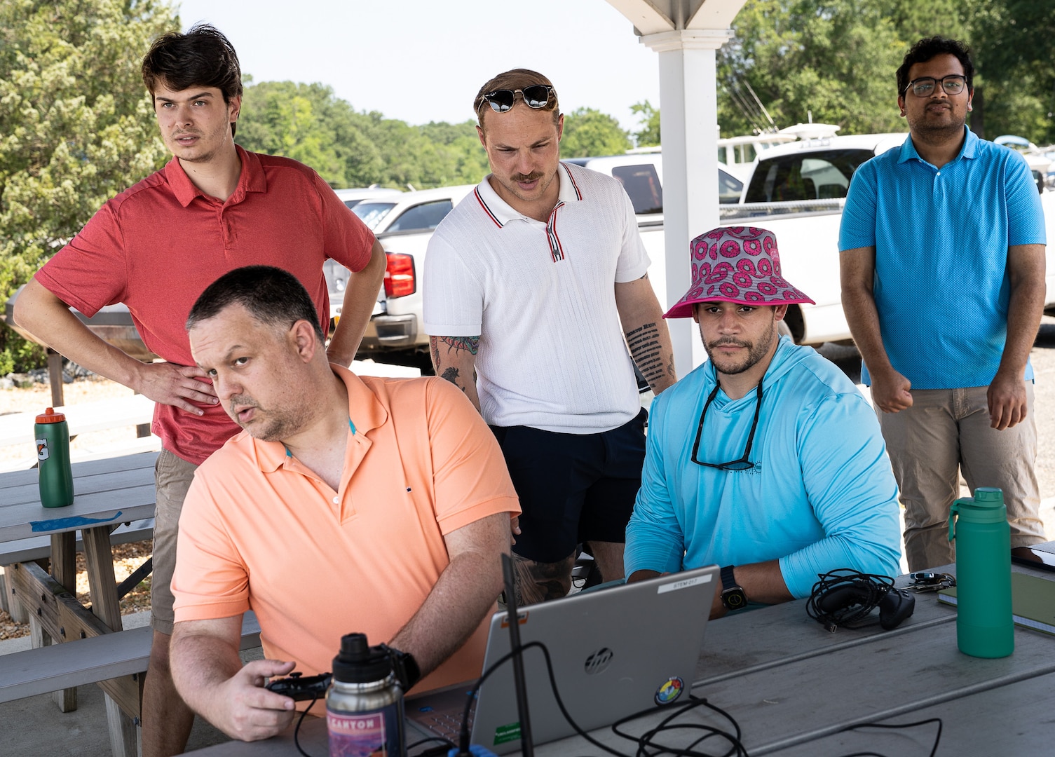 Naval Surface Warfare Center Dahlgren Division (NSWCDD) engineers Jeremiah Brown (seated left), (standing from left to right) James Caputo, Spencer Miller and Rishi Patel monitor their BlueBoat as it runs its mission in Machodoc Creek during a Workforce Development Innovation Challenge. NSWCDD scientist Luis Valcourt-Colon (seated right) from the Weapons Control and Integration Department’s Unmanned Control Systems Branch served as a mentor for the challenge. (Dave Ellis/NSWCDD Photo)