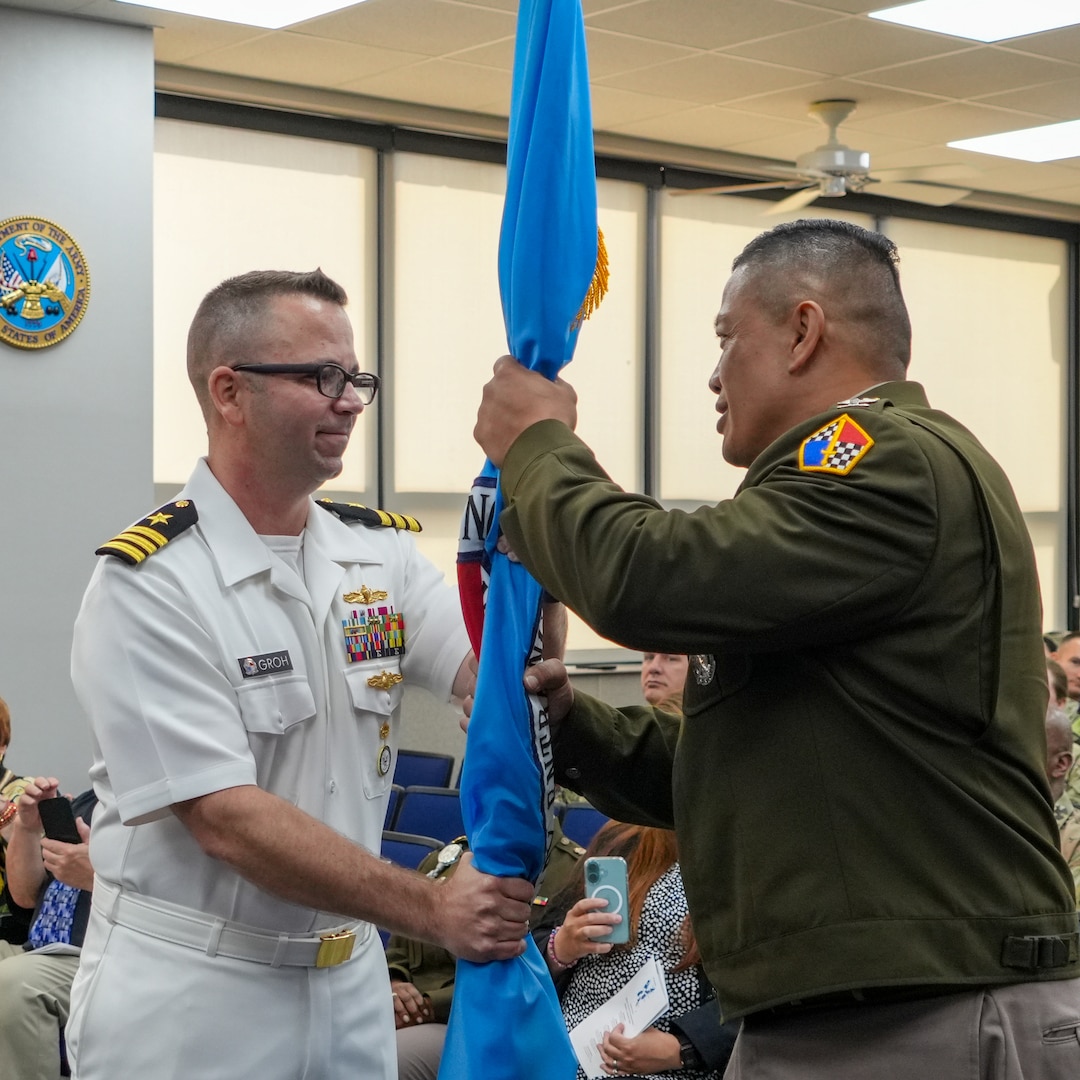 Navy Cmdr. Andrew Groh, acting USMEPCOM Eastern Sector Commander, transfers the responsibility of Eastern Sector by passing the organization's colors to Col. Cochiaosue, USMEPCOM commander. USMEPCOM held an Assumption of Command ceremony for its Eastern Sector on June 2 in North Chicago, Ill.