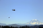 A UH-60 Blackhawk Helicopter from Charlie Company, 1st Battalion, 140th Aviation, 96th Troop Command, Washington Army National Guard conducts water bucket training with Central Pierce Fire and Rescue, June 30, 2025, near Puyallup, Wash.