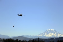 A UH-60 Blackhawk Helicopter from Charlie Company, 1st Battalion, 140th Aviation, 96th Troop Command, Washington Army National Guard conducts water bucket training with Central Pierce Fire and Rescue, June 30, 2025, near Puyallup, Wash.