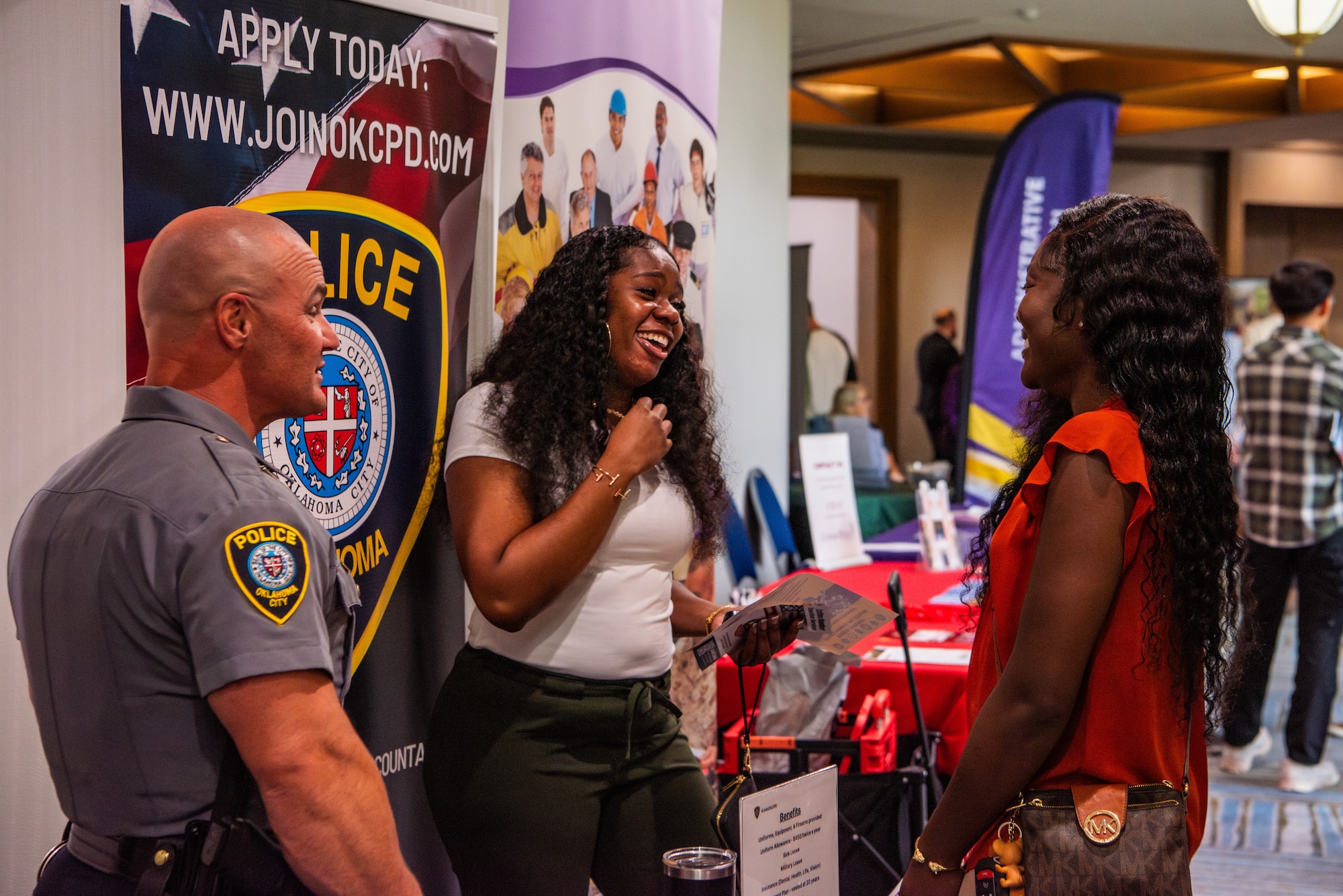Attendees laugh at an event booth.