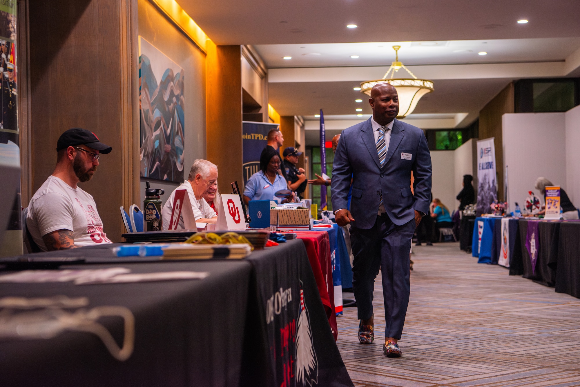 A man in a suit visits event booths.