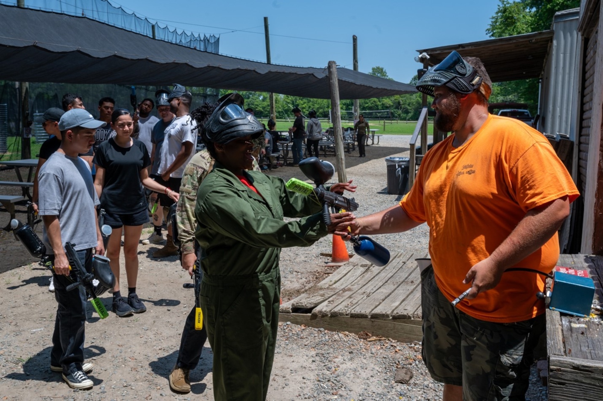 Man gives airsoft equipment to Airmen. (U.S. Air Force photo by Airman 1st Class Donnell Ramsey)