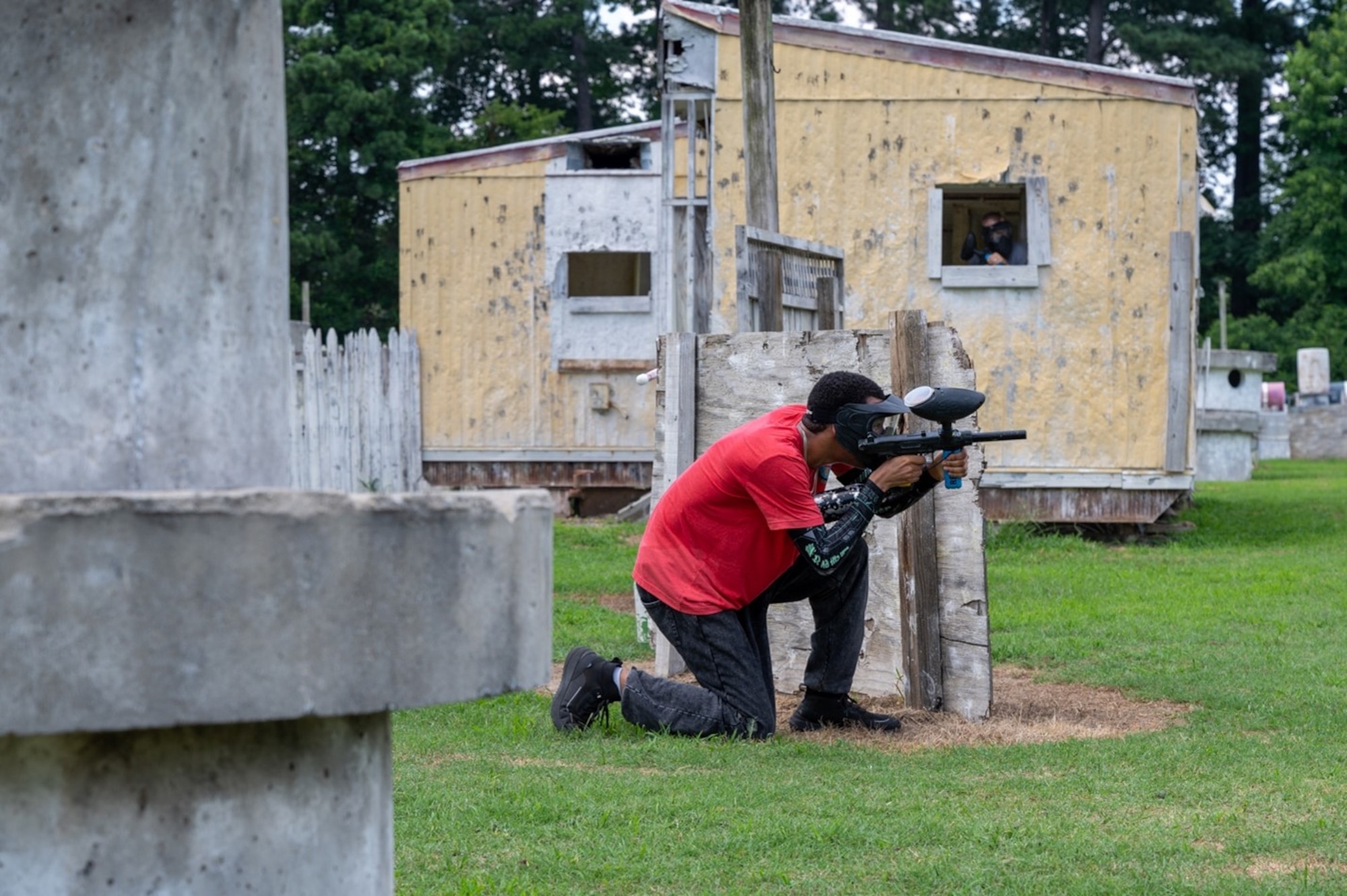 Airman aims an airsoft gun kneeling. (U.S. Air Force photo by Airman 1st Class Donnell Ramsey)