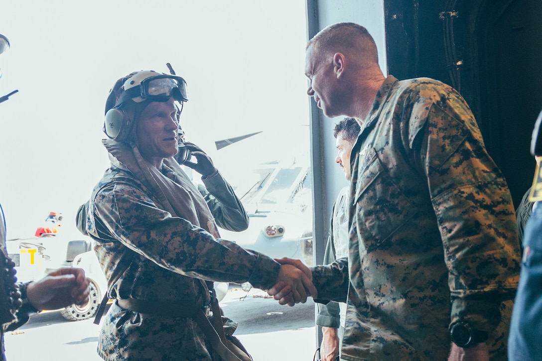 U.S. Marine Corps Col. Thomas Trimble, right, Commanding Officer, 22nd Marine Expeditionary Unit (Special Operations Capable), greets Brigadier General James Lively, left, Assistant Division Commander, 2nd Marine Division, during his visit aboard the Wasp-class amphibious assault ship USS Iwo Jima (LHD 7), during Composite Training Unit Exercise while underway in the Atlantic Ocean, June 24, 2025. During COMPTUEX, the IWO ARG and 22nd MEU(SOC), refine tactics, techniques, and procedures to execute warfighting functions that enhance operational readiness and lethality as a unified IWOARG/22MEU(SOC) team. (U.S. Marine Corps photo by Cpl. Sharon Errisuriz)