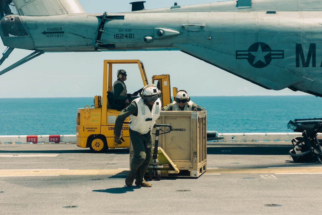 U.S. Marines with Combat Cargo, 22nd Marine Expeditionary Unit (Special Operations Capable), offload supplies from a CH-53E Super Stallion helicopters aboard the U.S. Navy Wasp-class amphibious assault ship USS Iwo Jima (LHD 7), during combat cargo operations in support of Composite Training Unit Exercise while underway in the Atlantic Ocean, June 22, 2025. During COMPTUEX, the IWO ARG and 22nd MEU(SOC), refine tactics, techniques, and procedures to execute warfighting functions that enhance operational readiness and lethality as a unified IWOARG/22 MEU(SOC) team. (U.S. Marine Corps photo by Sgt. Tanner Bernat)
