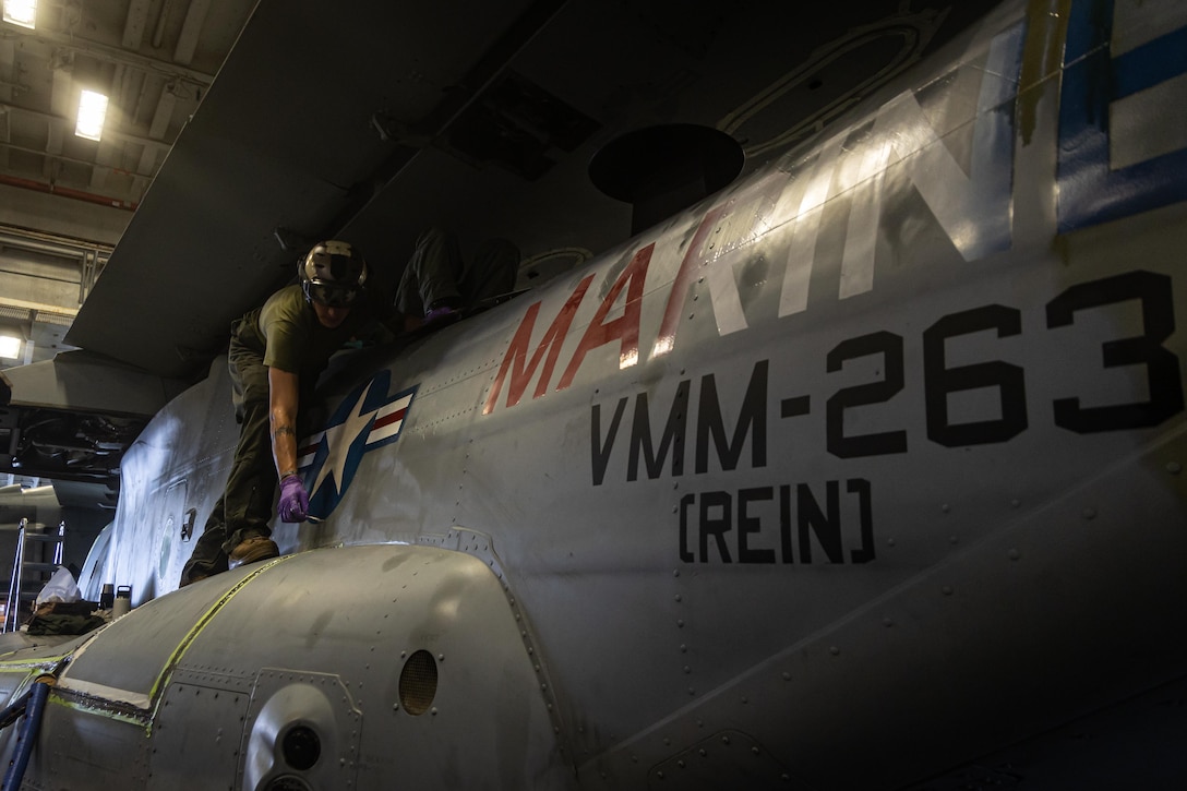 U.S. Marine Corps Cpl. Andrew Walter, a crew chief with Marine Medium Tiltrotor 263 (reinforced), 22nd Marine Expeditionary Unit (Special Operations Capable), conducts exterior maintenance on an MV-22 Osprey aboard the U.S. Navy Wasp-class amphibious assault ship USS Iwo Jima (LHD 7), in support of Composite Training Unit Exercise while underway in the Atlantic Ocean, June 24, 2025. During COMPTUEX, the IWO ARG and 22nd MEU(SOC), refine tactics, techniques, and procedures to execute warfighting functions that enhance operational readiness and lethality as a unified IWOARG/22 MEU(SOC) team. (U.S. Marine Corps photo by Cpl. Emily Hazelbaker)