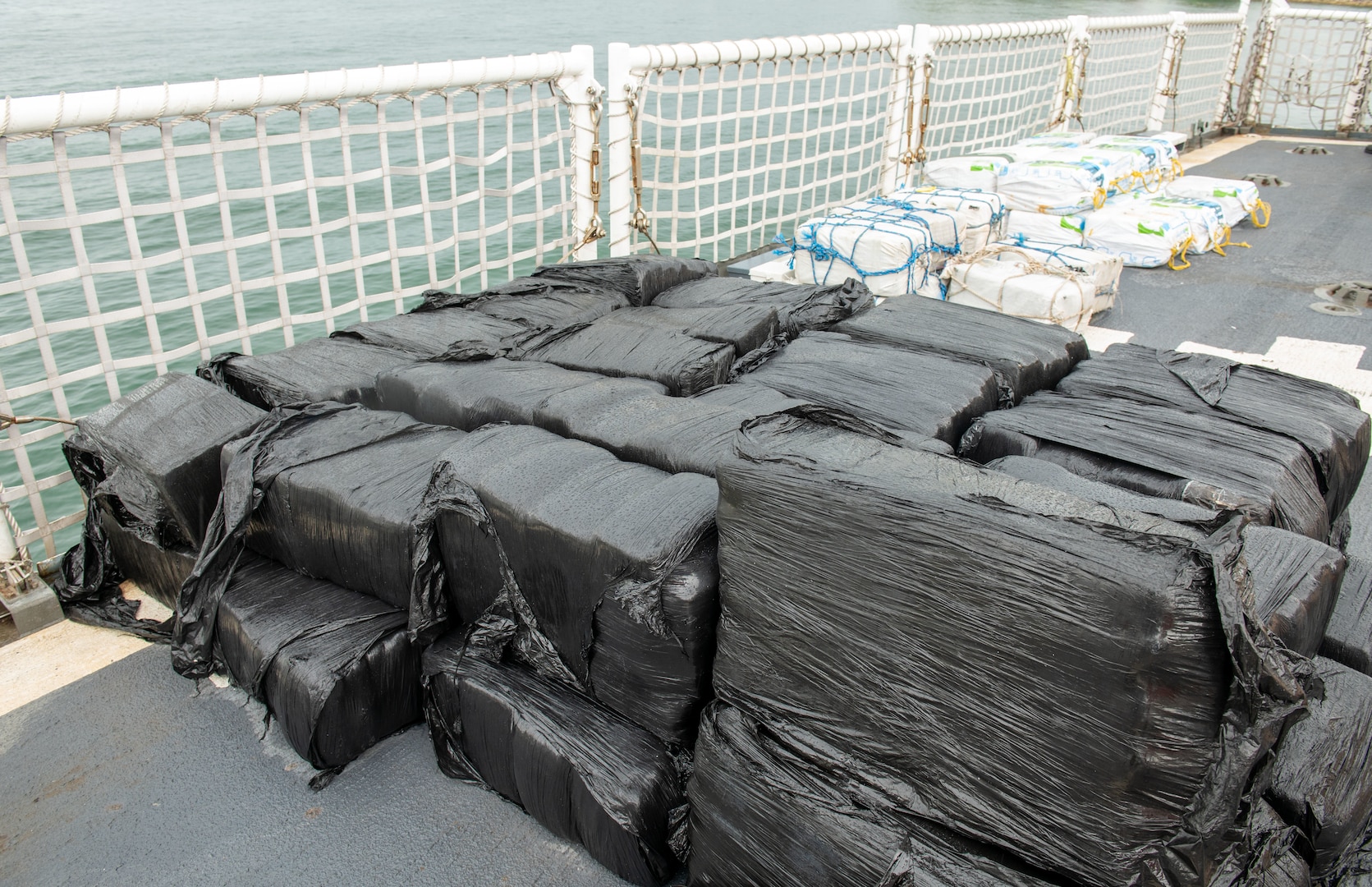 Illicit drugs sit on a flight deck of a Coast Guard cutter