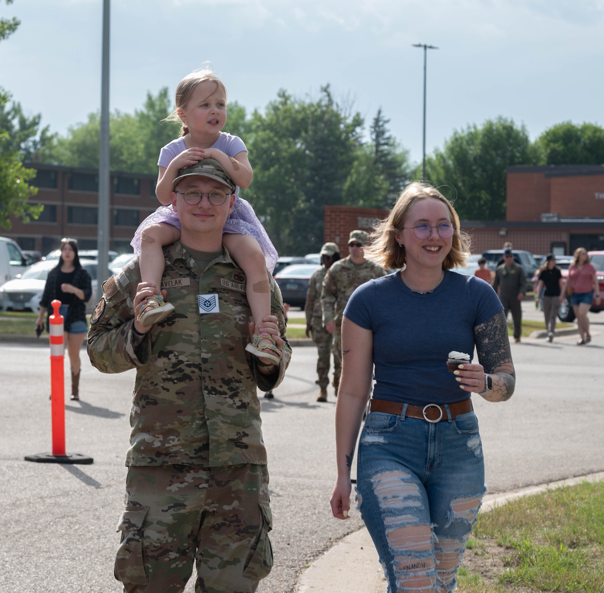 A family walks towards the festivities at Minot Air Force Base, North Dakota, June 27, 2025. Freedom Fest provided an opportunity for Airmen and their families to connect with the base community and support several local private organizations. (U.S. Air Force photo by Airman 1st Class Wesley Davies)