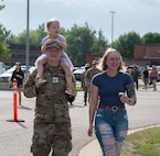 A family walks towards the festivities at Minot Air Force Base, North Dakota, June 27, 2025. Freedom Fest provided an opportunity for Airmen and their families to connect with the base community and support several local private organizations. (U.S. Air Force photo by Airman 1st Class Wesley Davies)