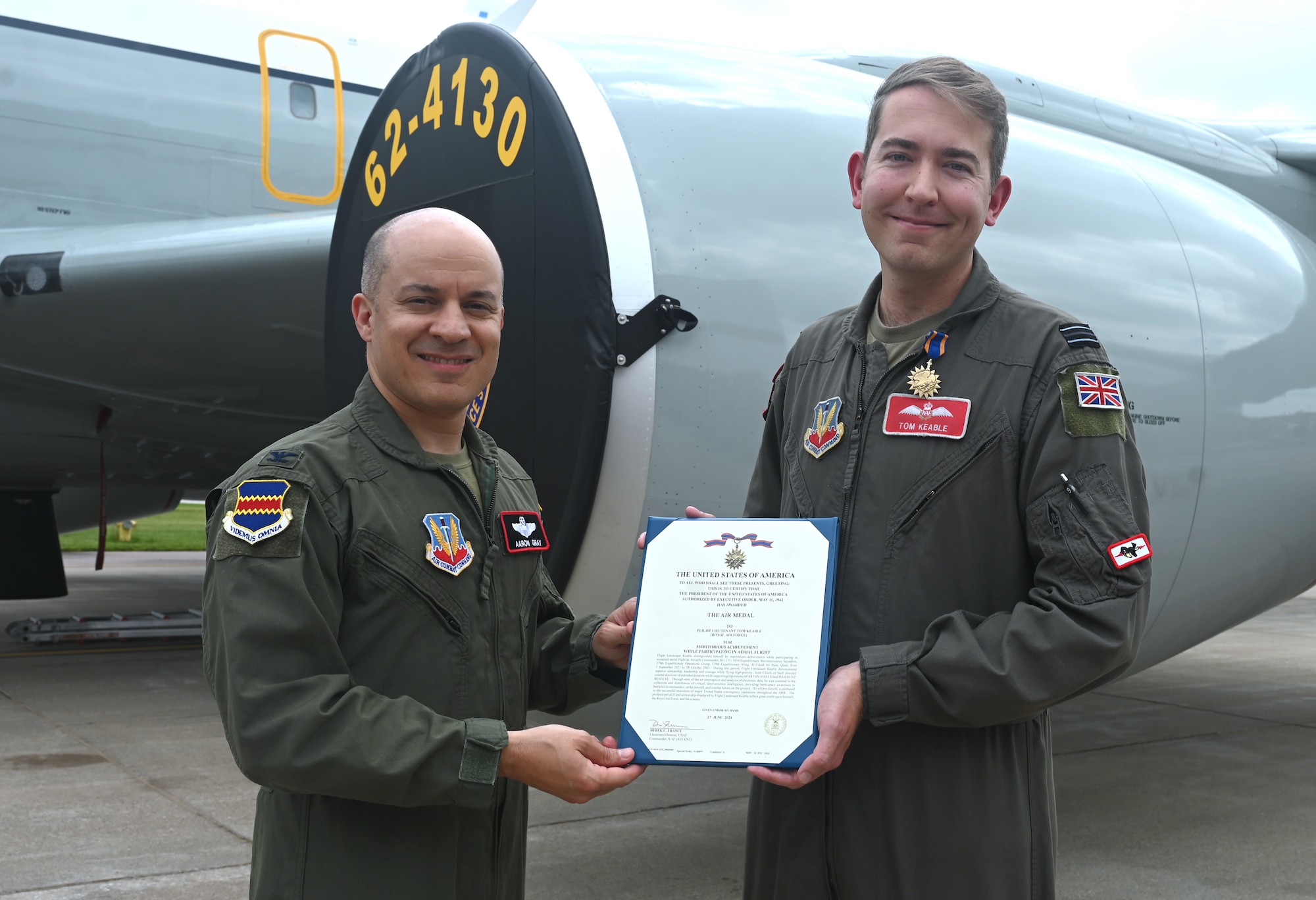 Col. Gray gives Armed Forces Air Medal certificate to Royal Air Force member.