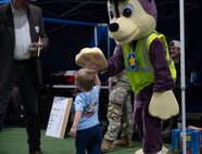 A child high-fives a mascot during Freedom Fest at Minot Air Force Base, North Dakota, June 27, 2025. Freedom Fest had music, food, games and fireworks for the Team Minot community to enjoy. (U.S. Air Force photo by Airman 1st Class Wesley Davies)