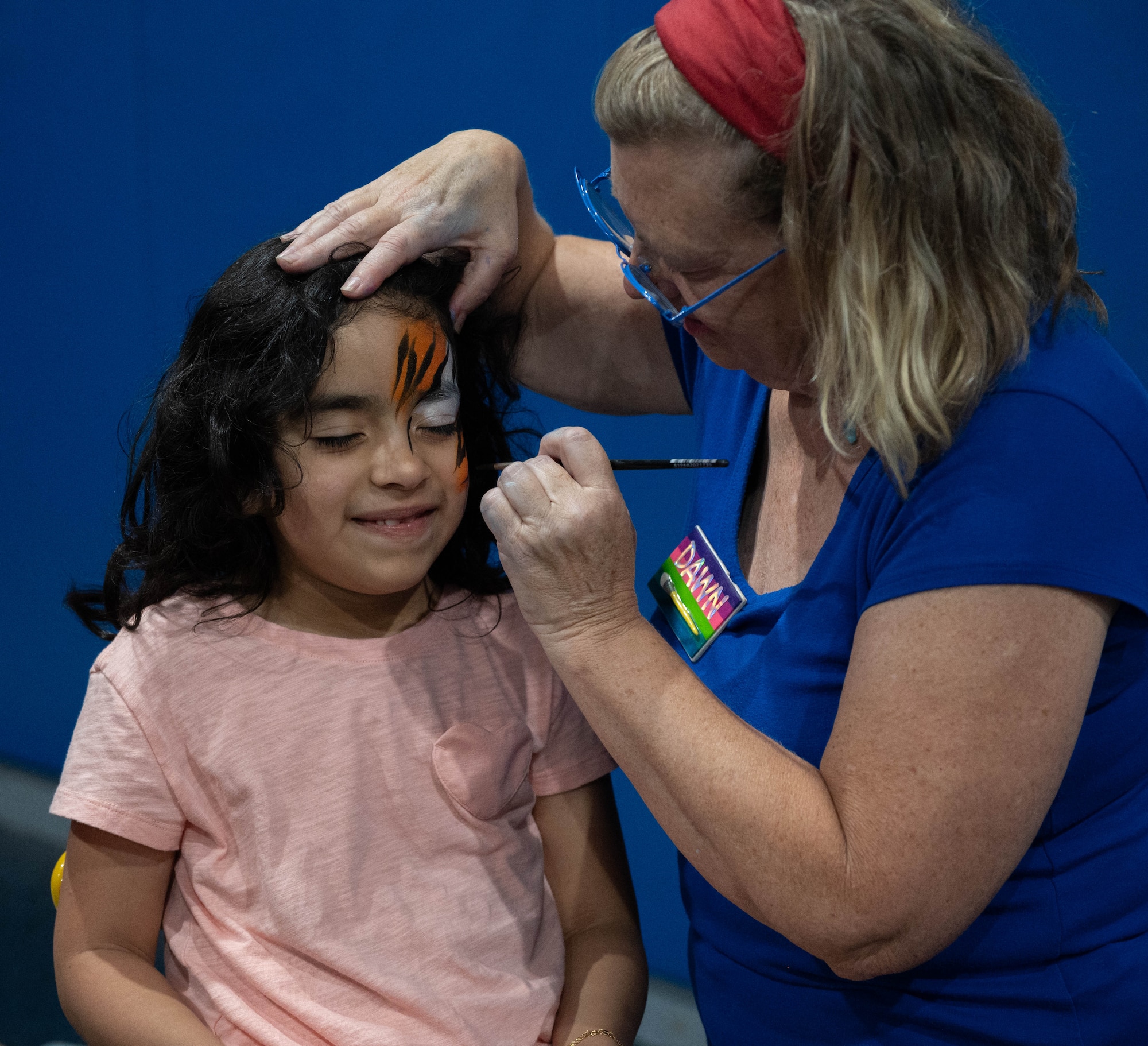 A child gets their face painted during Freedom Fest at Minot Air Force Base, North Dakota, June 27, 2025. Freedom Fest provided an opportunity for Airmen and their families to connect with the base community and support several local private organizations. (U.S. Air Force photo by Airman 1st Class Wesley Davies)