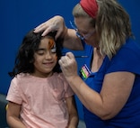 A child gets their face painted during Freedom Fest at Minot Air Force Base, North Dakota, June 27, 2025. Freedom Fest provided an opportunity for Airmen and their families to connect with the base community and support several local private organizations. (U.S. Air Force photo by Airman 1st Class Wesley Davies)