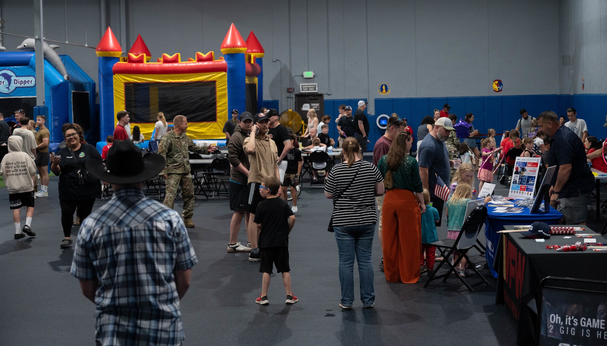 Airmen and their families gather to play and visit the booths of private organizations during Freedom Fest at Minot Air Force Base, North Dakota, June 27, 2025. Airmen and their families enjoyed an evening filled with meals from food vendors, music and a fireworks display that fostered a connection with the community. (U.S. Air Force photo by Airman 1st Class Wesley Davies)