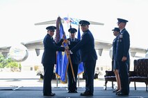 A photo of two Airmen holding a guidon.