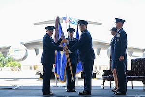 A photo of two Airmen holding a guidon.