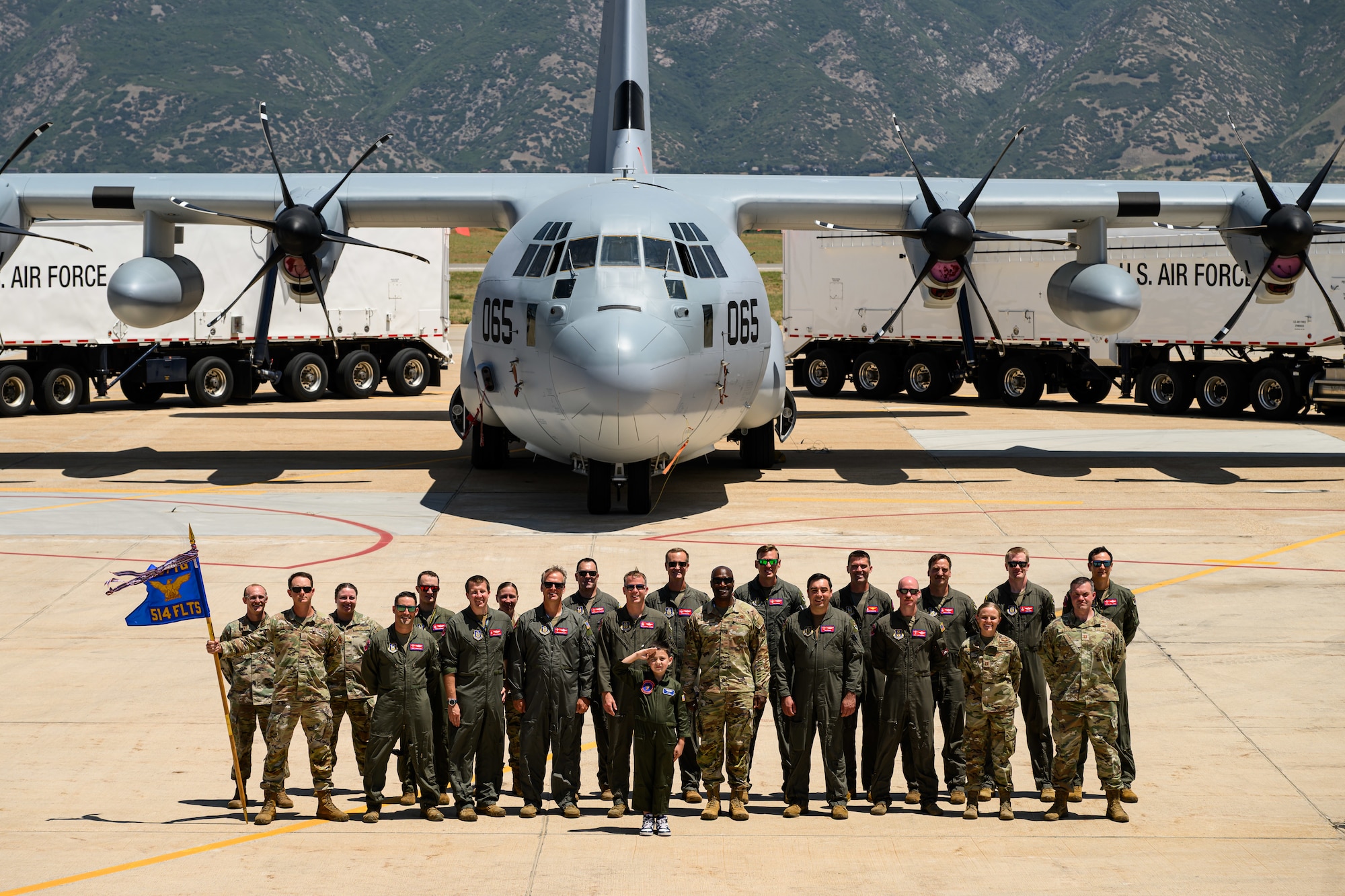 A group photo in front of a C-130 Hercules aircraft.