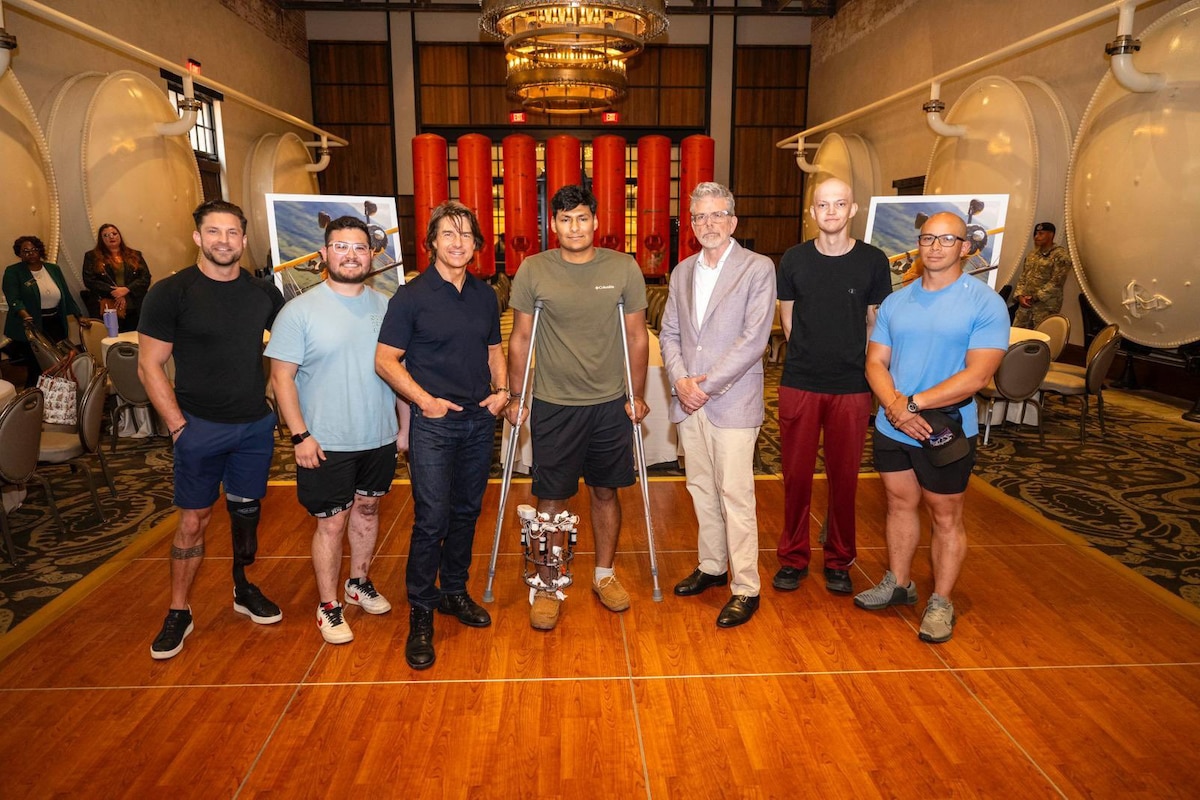 Seven people pose for a photo in a ballroom.