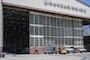 Airman walking in front of a large hangar.