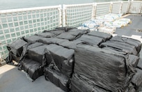 Illicit drugs sit on a flight deck of a Coast Guard cutter