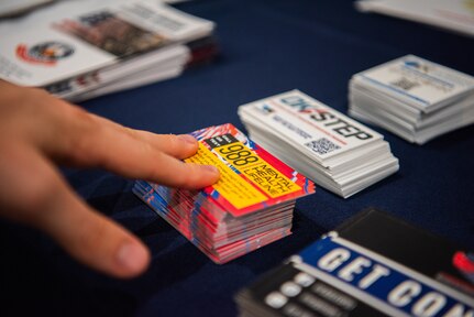 An attendee touches a 988 helpline card.