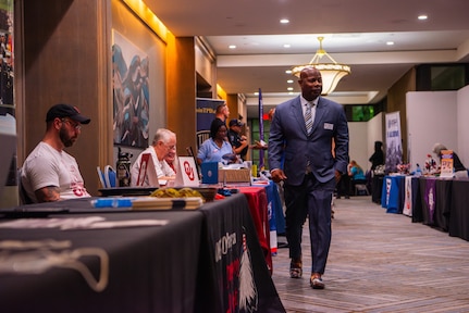 A man in a suit visits event booths.