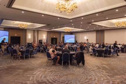 Attendees eat at tables in an open room.