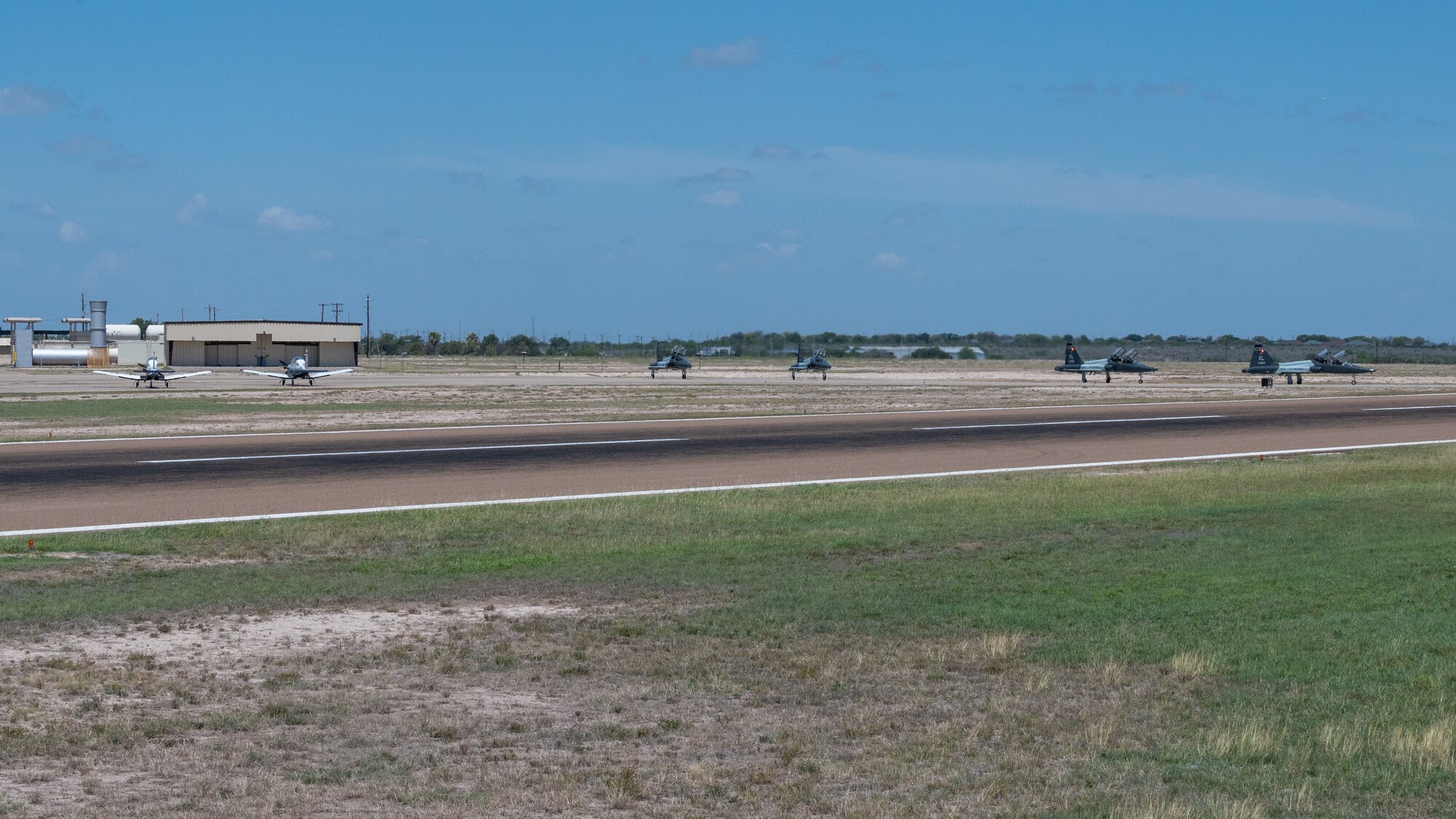 U.S. Air Force T-6A Texan II and T-38C Talon aircraft prepare to take off during an Uncontrolled Airfield Operations exercise at Laughlin Air Force Base, Texas, June, 26, 2025. The exercise simulated the tower being offline and unable to direct aircraft, forcing aircraft to rely on the Runway Supervisory Units to help ensure safety and operations. (U.S. Air Force photo by Staff Sgt. Nicholas Larsen)